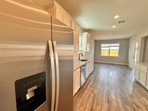 a kitchen with a refrigerator and wooden floor