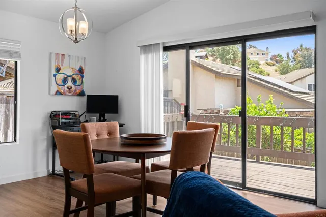 a view of a dining room with furniture a chandelier and wooden floor