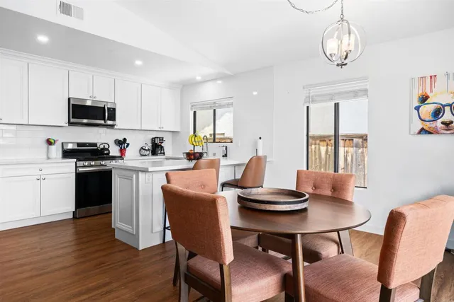 a kitchen with a dining table chairs and microwave