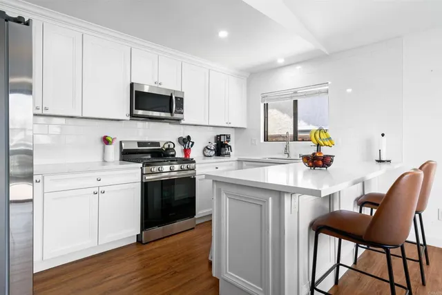 a kitchen with a sink cabinets and wooden floor