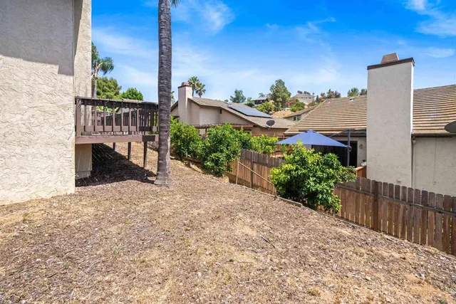 a view of a roof deck with wooden fence and plants