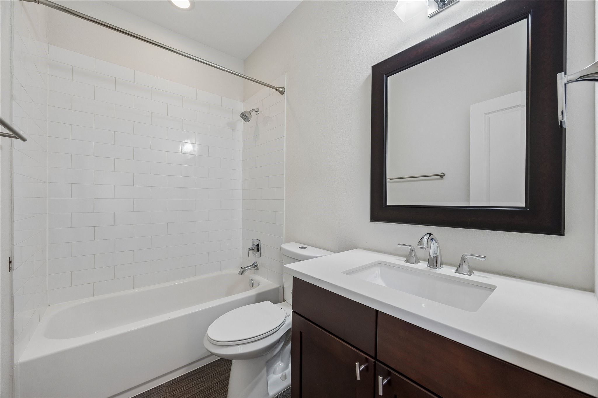 734 West 20th Street, Unit A Houston, TX 77008 - Photo 20 of 23 First-floor ensuite bath offers a tub/shower combo w/ tile surround, beautiful vanity, framed mirror & clean, modern finishes.