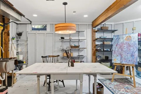 a kitchen with stainless steel appliances granite countertop a kitchen island a stove a refrigerator a dining table and chairs with wooden floor