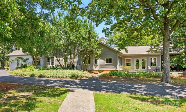 a view of a house with a yard and tree s