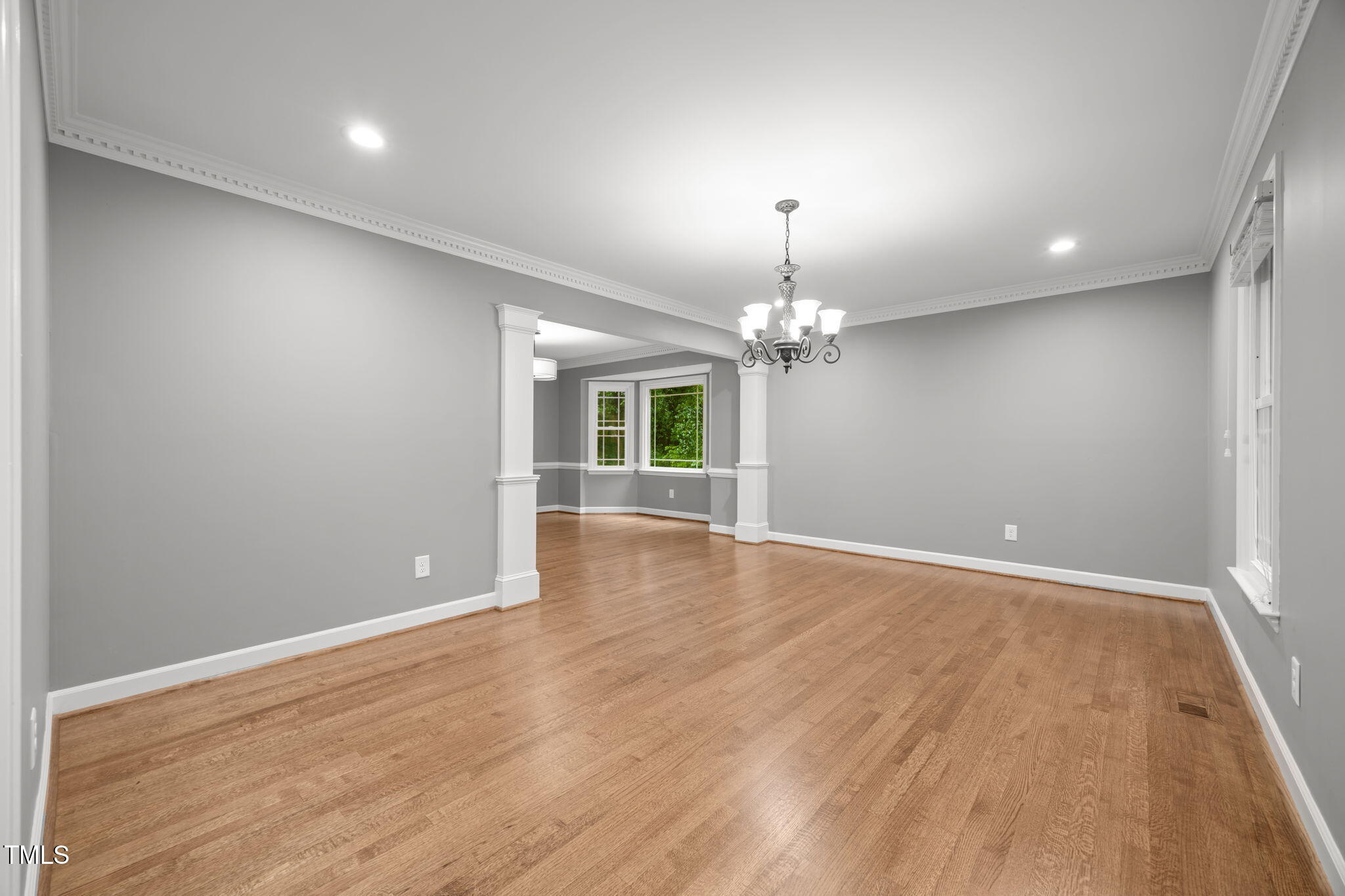 2204 Corberrie Lane Raleigh, NC 27613 - Photo 6 of 39 an empty room with wooden floor chandelier and fireplace