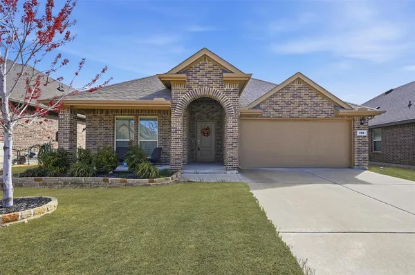 a front view of a house with yard and green space