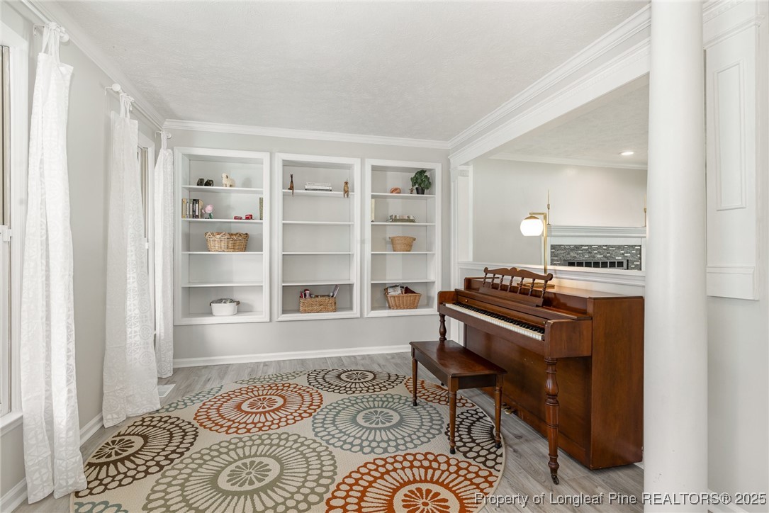 7810 Shuttle Road Fayetteville, NC 28311 - Photo 5 of 25 a living room with a piano and a bookshelf