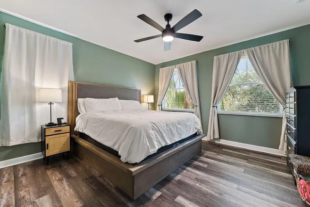a spacious bedroom with a large bed chandelier and a large window