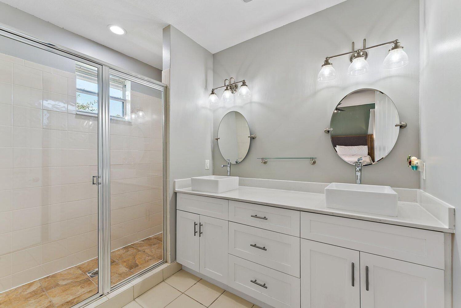 500 Pacific Grove Drive, Unit 8 West Palm Beach, FL 33401 - Photo 15 of 35 a bathroom with a double vanity sink mirror and shower