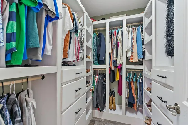 a view of walk in closet with clothes and shoes