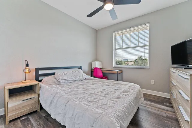 a bedroom with a large bed and a flat tv screen on dresser