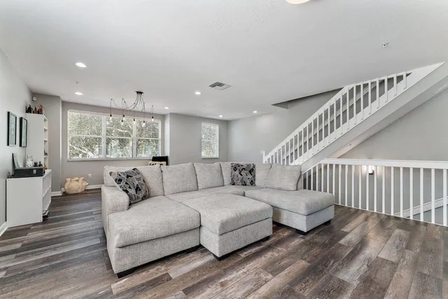 a living room with furniture and wooden floor