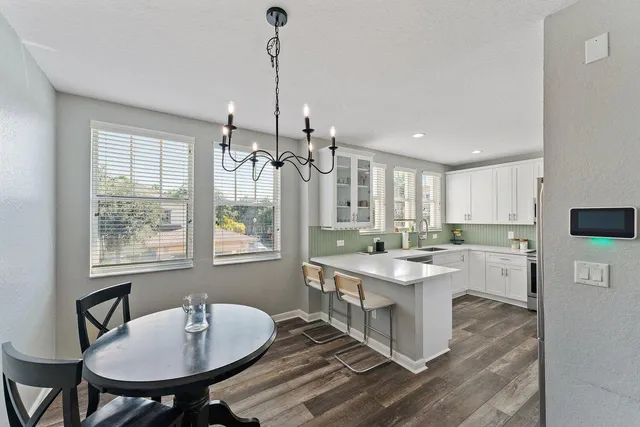 a room with a table chairs and kitchen view