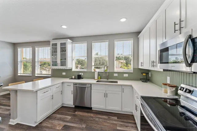 a kitchen with a sink stove top oven and cabinets