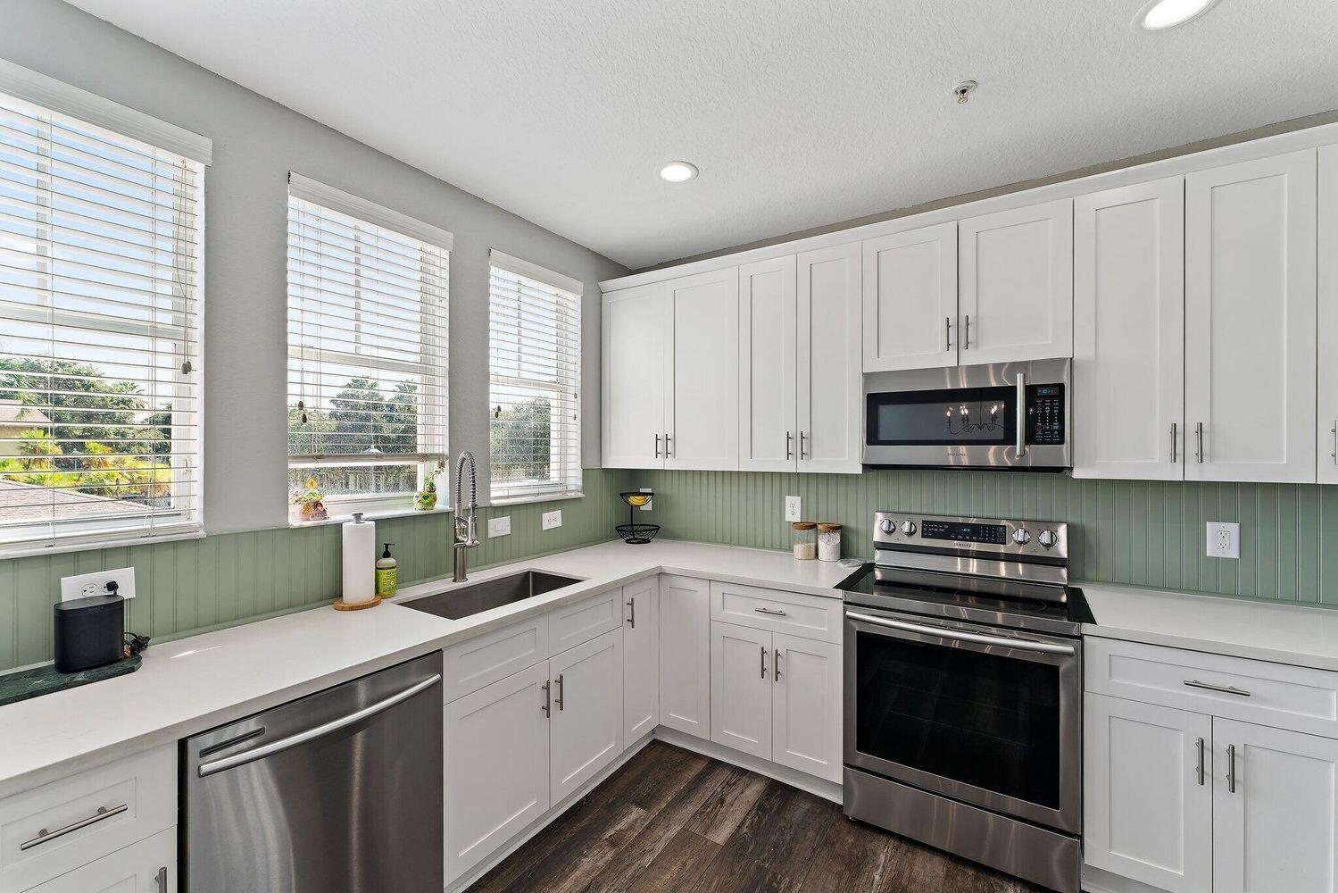 500 Pacific Grove Drive, Unit 8 West Palm Beach, FL 33401 - Photo 10 of 35 a kitchen with a sink stove top oven and cabinets