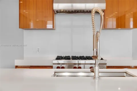 a large white kitchen with cabinets and chairs