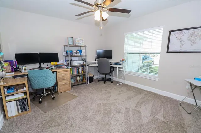 a view of a workspace with furniture and a window