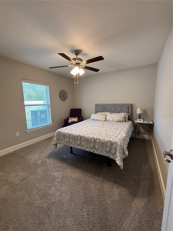 10396 Southwest 45th Avenue Ocala, FL 34476 - Photo 16 of 18 a bedroom with a bed window and a chandelier