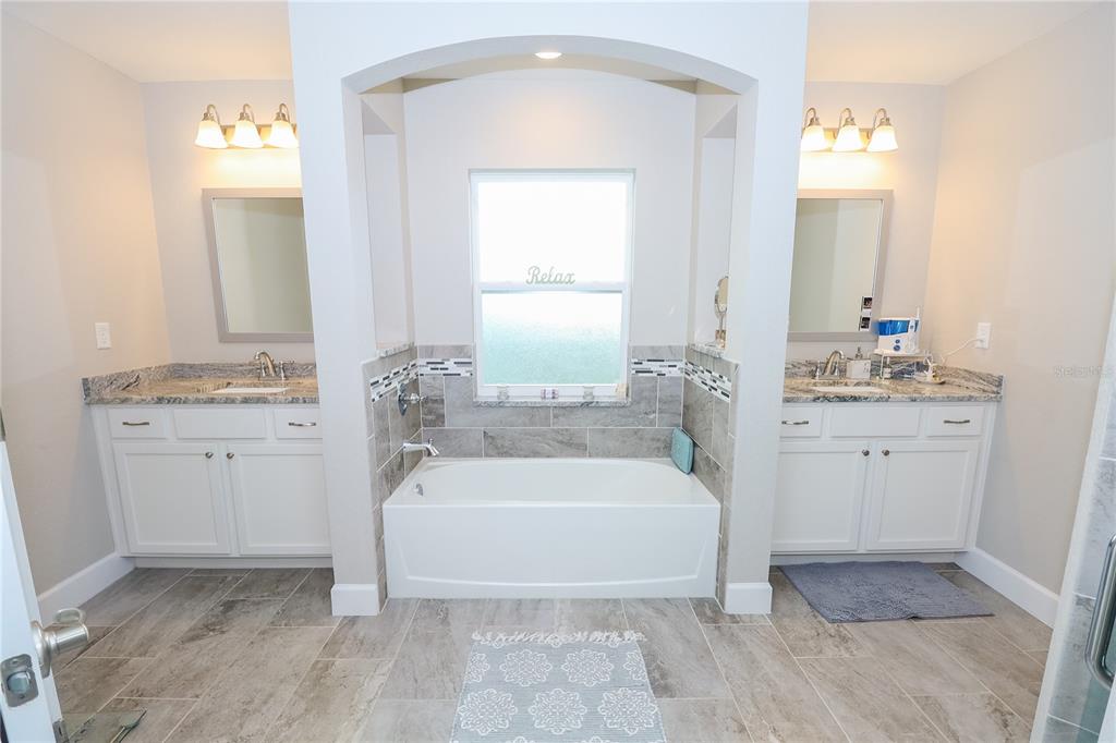 10396 Southwest 45th Avenue Ocala, FL 34476 - Photo 4 of 18 a spacious bathroom with a tub sink and mirror