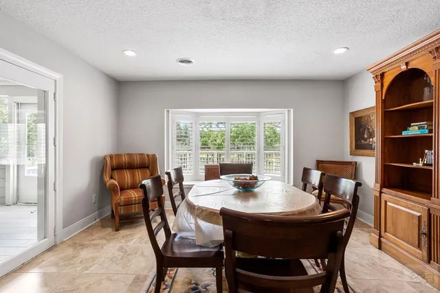 a dining room with wooden floor and a rug