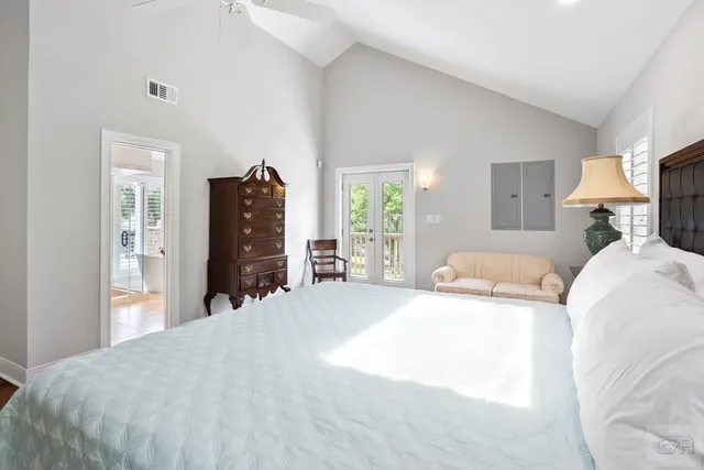 a spacious bedroom with a bed a dresser and potted plants