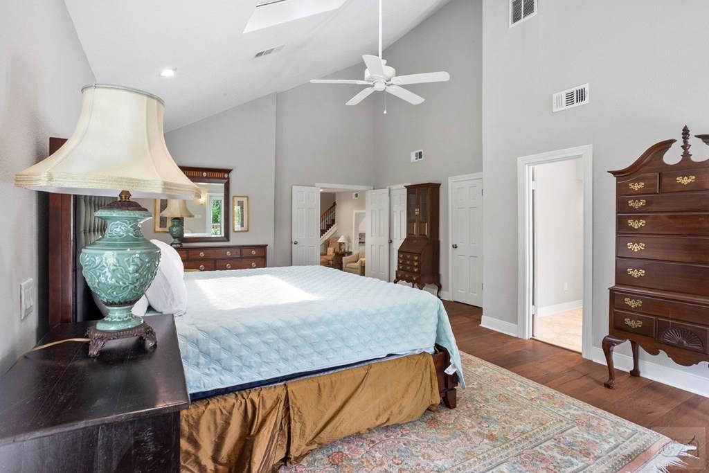 14009 West Hughes Road Dickinson, TX 77539 - Photo 16 of 54 a spacious bedroom with a bed a dresser and potted plants