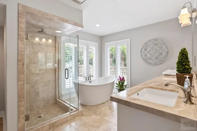 a spacious bathroom with a granite countertop sink a large mirror and a window