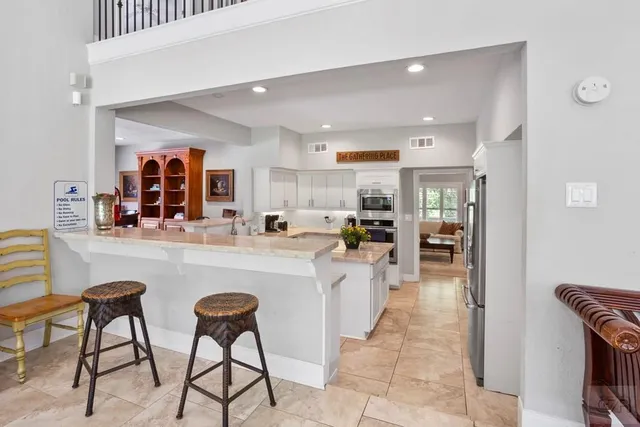 a kitchen with stainless steel appliances granite countertop a table and chairs in it
