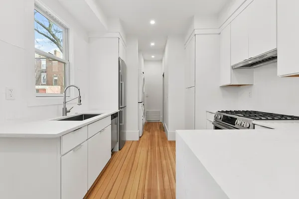 a kitchen with a sink a stove and cabinets