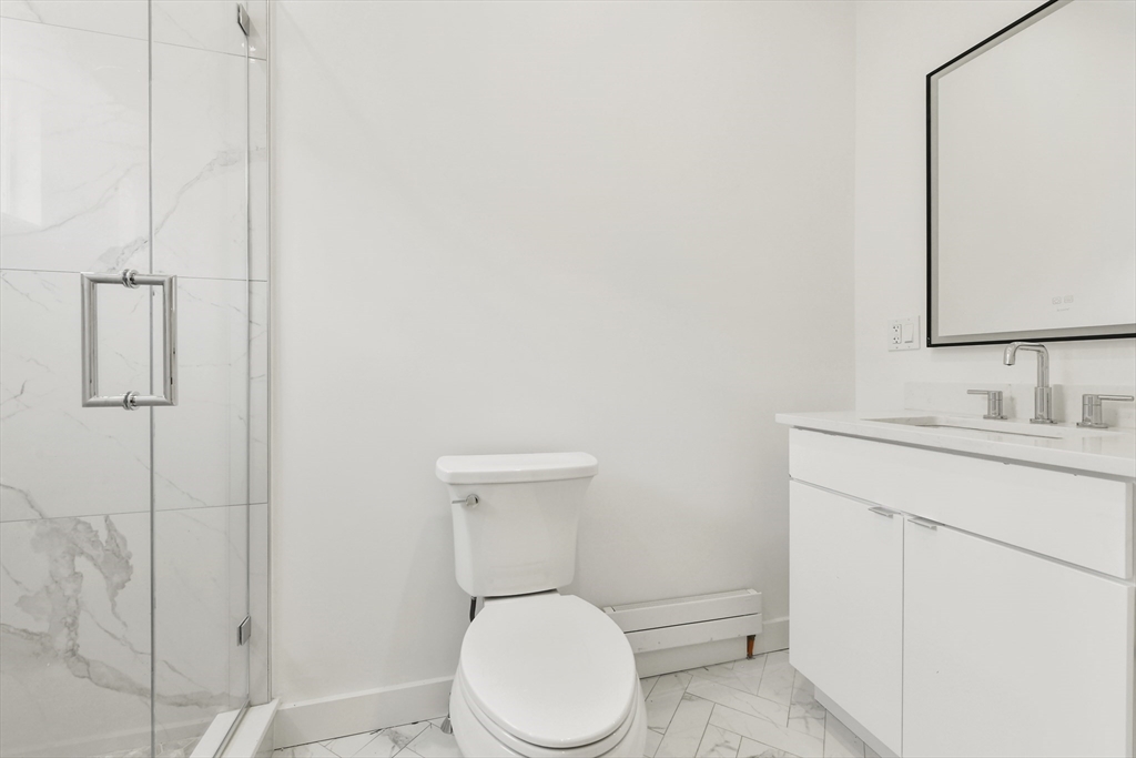 31 Pleasant Street, Unit 1 Boston, MA 02129 - Photo 5 of 8 a bathroom with a toilet sink and shower