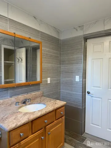 a bathroom with a granite countertop sink and a mirror