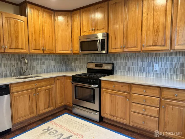 a kitchen with stainless steel appliances granite countertop wooden cabinets a stove a sink and dishwasher