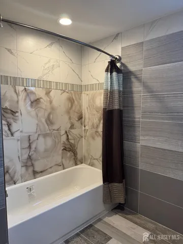a bathroom with a bathtub and shower
