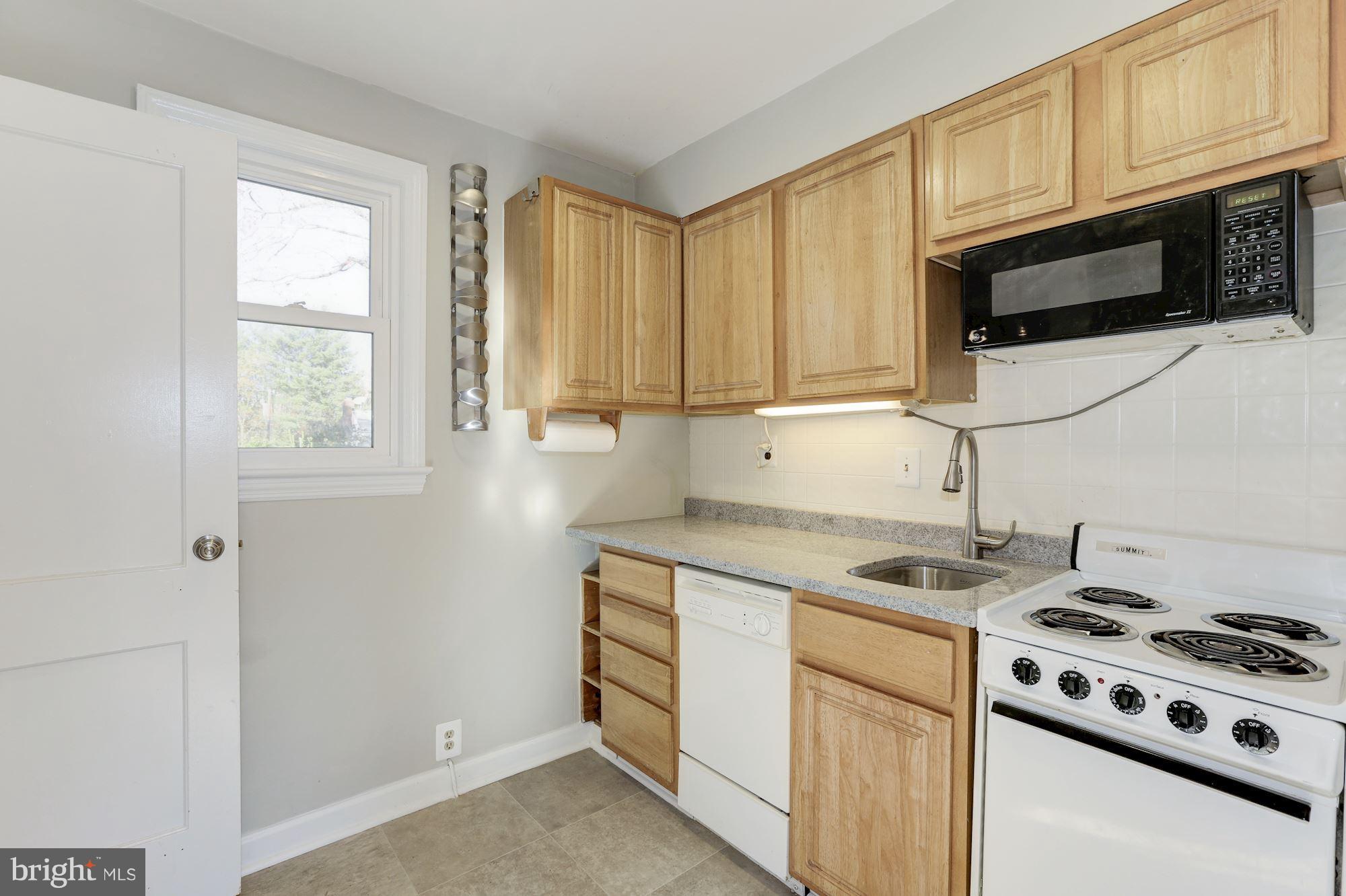 5018 Laguna Road College Park, MD 20740 - Photo 12 of 30 a kitchen with stainless steel appliances granite countertop white cabinets and a stove top oven