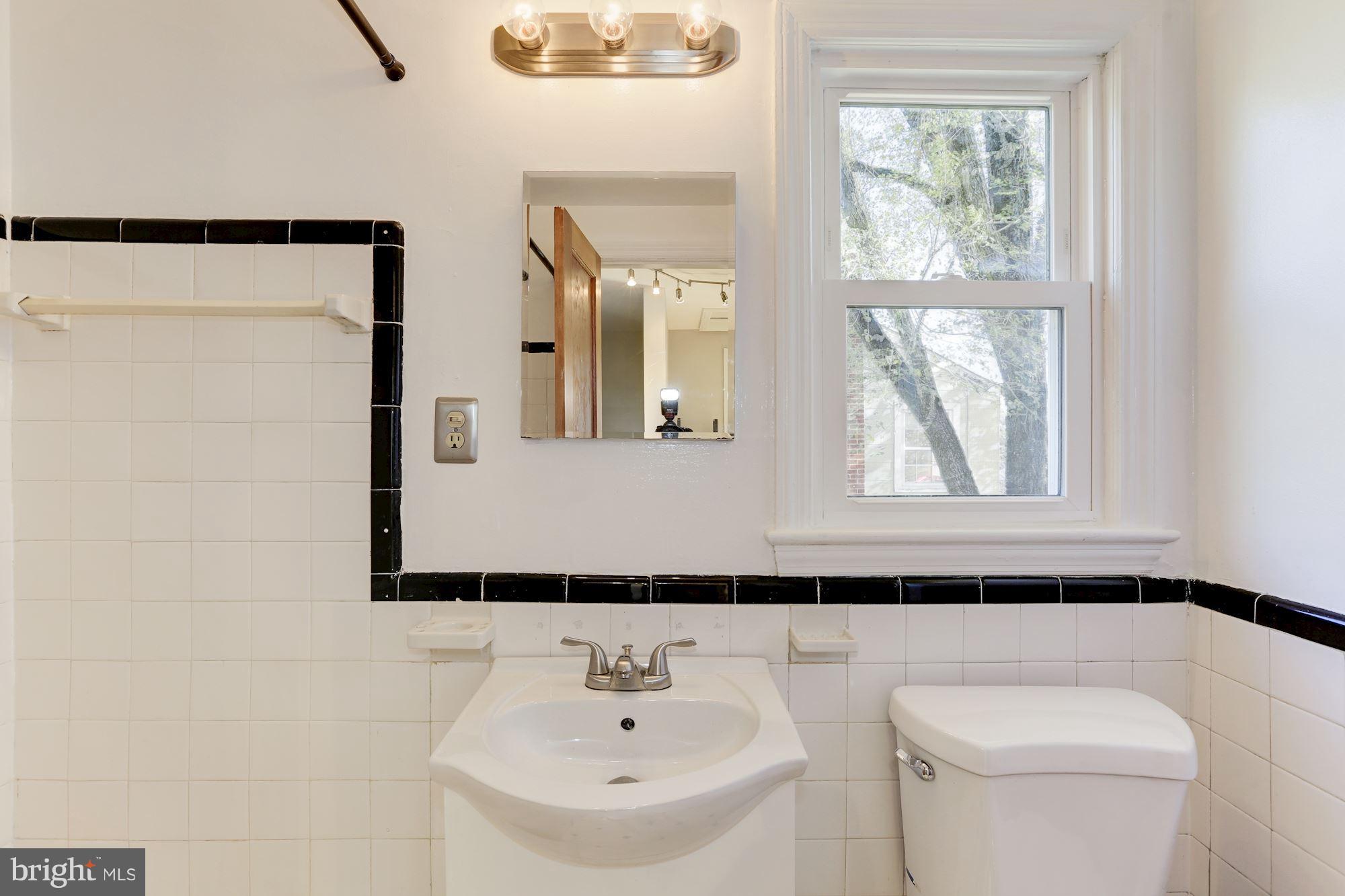 5018 Laguna Road College Park, MD 20740 - Photo 20 of 30 a bathroom with a sink a toilet and a mirror