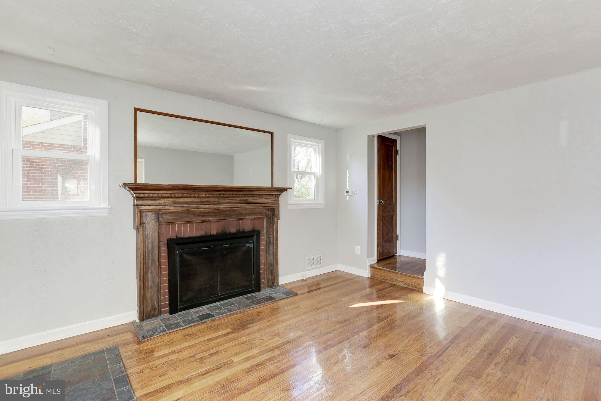 5018 Laguna Road College Park, MD 20740 - Photo 5 of 30 a view of an empty room with wooden floor fireplace and a window