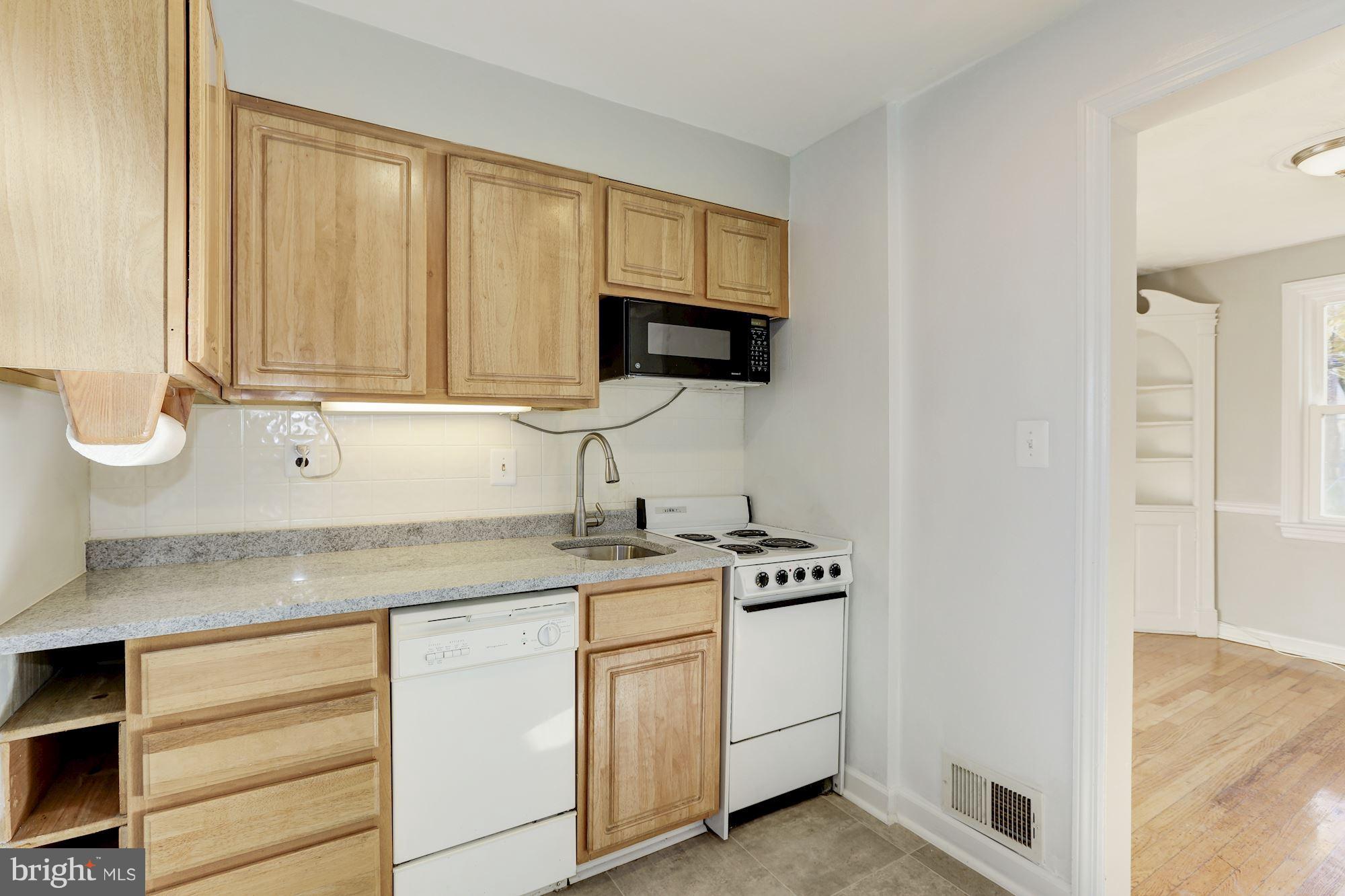 5018 Laguna Road College Park, MD 20740 - Photo 10 of 30 a kitchen with stainless steel appliances granite countertop a sink stove and microwave