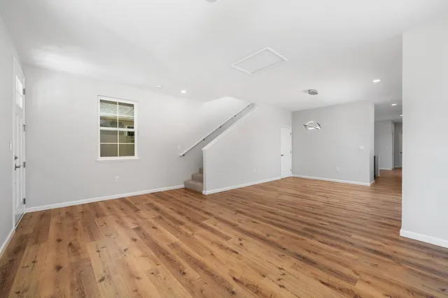 a view of a big room with wooden floor and windows