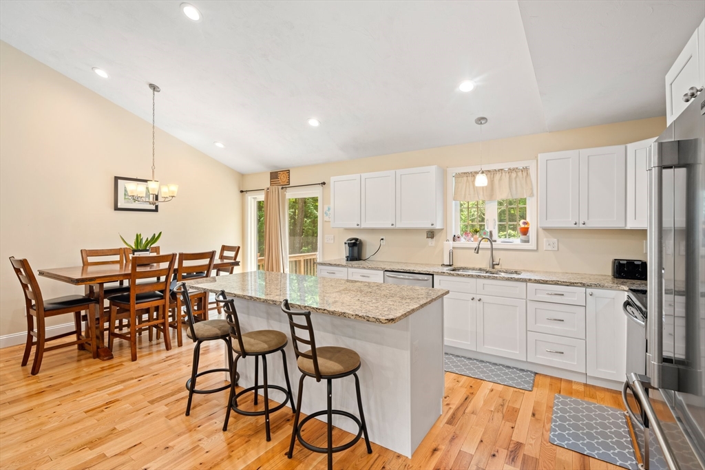 190 Lower Gore Road Webster, MA 01570 - Photo 17 of 41 a kitchen with stainless steel appliances granite countertop dining table chairs cabinets and wooden floor