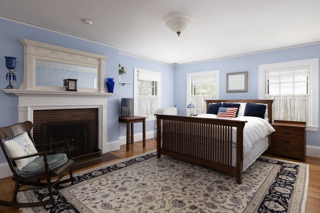 175 Mt Vernon Street Newton, MA 02465 - Photo 10 of 21 a bedroom with a large bed and a fireplace