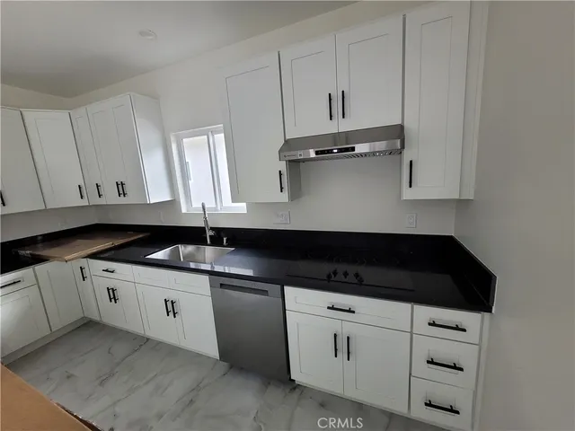 a kitchen with granite countertop white cabinets and sink