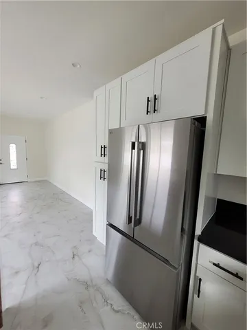 a view of kitchen with refrigerator stove and cabinets