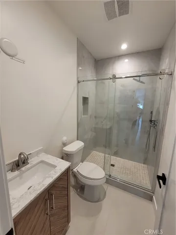 a bathroom with a granite countertop sink a toilet and shower
