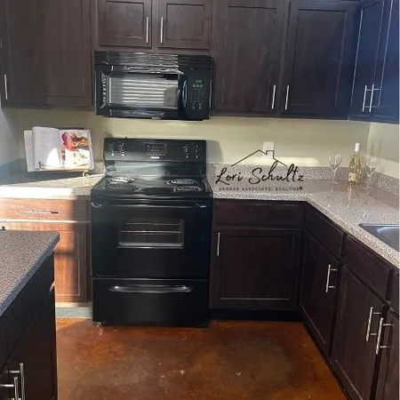 a kitchen with granite countertop a stove and a sink