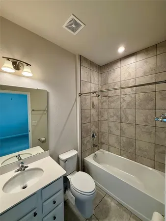 a bathroom with a bathtub shower sink mirror vanity and toilet