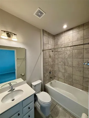 a bathroom with a bathtub shower sink mirror vanity and toilet
