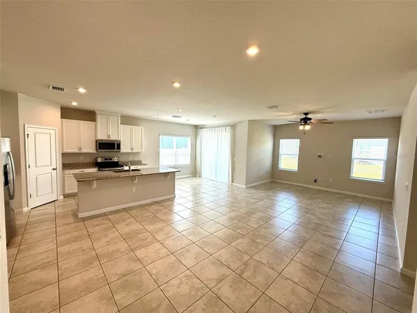 a view of kitchen with refrigerator and cabinets