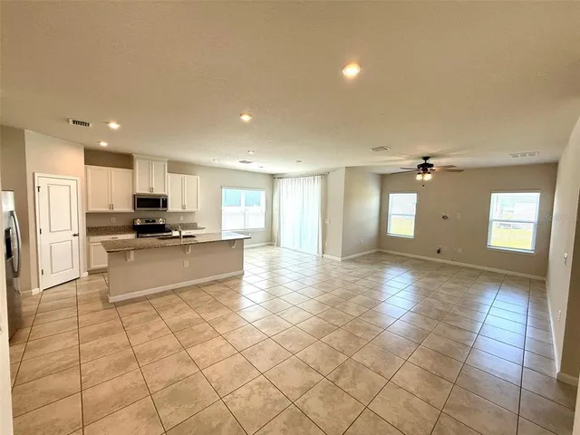 a view of kitchen with refrigerator and cabinets