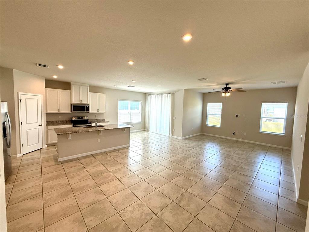 5576 Vigo Loop St. Cloud, FL 34771 - Photo 3 of 17 a view of kitchen with refrigerator and cabinets