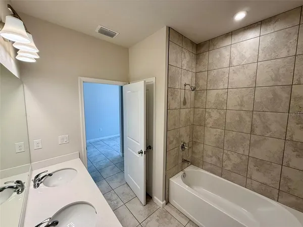a bathroom with a tub a mirror and a shower